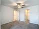 Spacious bedroom featuring neutral carpet, ceiling fan, and a double door closet at 4567 Tuscan Loon Dr, Tampa, FL 33619