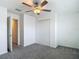 Spacious bedroom with neutral carpet, fan, and a double door closet for ample storage at 4567 Tuscan Loon Dr, Tampa, FL 33619