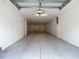View of an empty two car garage with white walls, recessed lighting, and space for storage and vehicles at 4567 Tuscan Loon Dr, Tampa, FL 33619