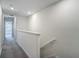Bright hallway featuring neutral walls, gray carpet, and stairway with wood railing at 4567 Tuscan Loon Dr, Tampa, FL 33619