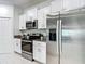 Sleek kitchen boasts stainless appliances, white cabinetry, and granite countertops for a modern look at 4567 Tuscan Loon Dr, Tampa, FL 33619