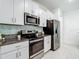 Modern kitchen with white cabinets, granite counters, stainless appliances, and tile backsplash at 4567 Tuscan Loon Dr, Tampa, FL 33619