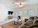 Open-concept living room with natural light, a comfortable sectional sofa, and a large area rug at 4567 Tuscan Loon Dr, Tampa, FL 33619
