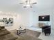 Open-concept living room with kitchen view, modern furnishings, and a ceiling fan at 4567 Tuscan Loon Dr, Tampa, FL 33619