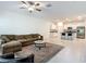 Spacious living room with a large sofa, ceiling fan, and an open view to the kitchen at 4567 Tuscan Loon Dr, Tampa, FL 33619
