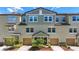 Exterior shot of multiple townhomes with tan garages and landscaping, featuring an appealing facade at 4567 Tuscan Loon Dr, Tampa, FL 33619