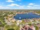 Aerial view showcasing a waterfront home on a canal with beautiful landscaping and city views in the distance at 5002 E Longboat Blvd, Tampa, FL 33615