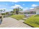 Backyard view featuring an outdoor living space, landscaped lawn, and wooden walkway to a private boat dock at 5002 E Longboat Blvd, Tampa, FL 33615
