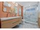 Modern bathroom features a double sink vanity, blue tiled shower, and hexagon tiled floor at 5002 E Longboat Blvd, Tampa, FL 33615