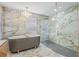 This elegant bathroom showcases a luxurious soaking tub and glass-enclosed shower with designer finishes at 5002 E Longboat Blvd, Tampa, FL 33615