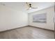 This bedroom features wood-look floors, base molding, a ceiling fan, and a window at 5002 E Longboat Blvd, Tampa, FL 33615