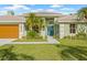 Well-maintained one-story house with a gray driveway, a green lawn, and a turquoise front door at 5002 E Longboat Blvd, Tampa, FL 33615
