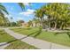 Side view of one-story house with a well-maintained lawn and tropical landscaping on a sunny day at 5002 E Longboat Blvd, Tampa, FL 33615