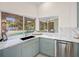 Kitchen view showcasing modern cabinets, marble countertops, and a large window overlooking the pool and backyard at 5002 E Longboat Blvd, Tampa, FL 33615