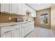 This laundry room features white cabinets, gold hardware, and a countertop with a sink at 5002 E Longboat Blvd, Tampa, FL 33615