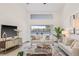 Well-decorated living room featuring a large flat screen TV and view to backyard pool at 5002 E Longboat Blvd, Tampa, FL 33615