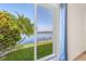 Gorgeous waterfront view from a large window, featuring a tropical palm tree and private dock at 5002 E Longboat Blvd, Tampa, FL 33615