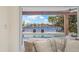 Beautiful water view of backyard pool from living room couch, with two chairs outside at 5002 E Longboat Blvd, Tampa, FL 33615