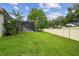Large green backyard with white fence and screened-in lanai at 505 Vintage Way, Brandon, FL 33511