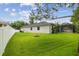 Large backyard featuring a lush lawn, white fence, and screened lanai at 505 Vintage Way, Brandon, FL 33511