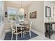 Charming breakfast nook with a round wood table, white chairs, and natural light from a large window at 505 Vintage Way, Brandon, FL 33511