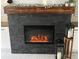 Close-up of the fireplace with a stone facade, wood mantel, and decorative accessories at 505 Vintage Way, Brandon, FL 33511