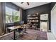 Home office with built-in bookshelves, a large window, ceiling fan, and dark walls at 505 Vintage Way, Brandon, FL 33511
