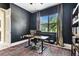 Office space featuring an executive desk with a leather chair, dark walls, and window views at 505 Vintage Way, Brandon, FL 33511