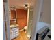 Cozy bathroom featuring a vanity, shower, and warm orange accent wall at 5105 Wood St, Zephyrhills, FL 33542