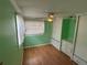 Serene bedroom with wood-look flooring, bright green walls, and built-in closet storage at 5105 Wood St, Zephyrhills, FL 33542