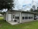 Home with a sunroom addition featuring multiple windows and attached carport at 5105 Wood St, Zephyrhills, FL 33542
