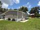 Cozy mobile home boasts a covered porch, landscaped yard with vibrant flowers, and convenient shed at 5105 Wood St, Zephyrhills, FL 33542