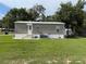 Single story home featuring light gray siding and a well maintained front yard at 5105 Wood St, Zephyrhills, FL 33542