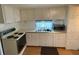 Efficient kitchen showcasing white cabinets, retro appliances, and ample counter space at 5105 Wood St, Zephyrhills, FL 33542