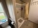 Shower stall featuring tile surround, updated hardware, and grab bar at 5105 Wood St, Zephyrhills, FL 33542