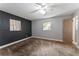 Spacious bedroom with textured accent wall, ceiling fan, and natural light from windows at 5210 Dr Martin Luther King Jr St N St, St Petersburg, FL 33703