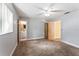 Bedroom with neutral walls, carpet flooring, ceiling fan, and doors to bathroom and hallway at 5210 Dr Martin Luther King Jr St N St, St Petersburg, FL 33703