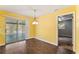 Cozy dining area featuring hardwood floors, bright yellow walls, and sliding doors to a screened-in patio at 5210 Dr Martin Luther King Jr St N St, St Petersburg, FL 33703