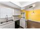 Bright kitchen featuring white cabinetry, stainless steel sink, and adjacent dining area at 5210 Dr Martin Luther King Jr St N St, St Petersburg, FL 33703
