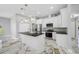 Modern kitchen with white cabinetry, stainless steel appliances, black countertops and marble floors at 5317 Lydia Ct, Spring Hill, FL 34608