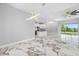 Open-concept living area featuring sleek marble floors, recessed lighting, and a view of the kitchen and backyard at 5317 Lydia Ct, Spring Hill, FL 34608