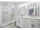Bright bathroom featuring a double vanity, a shower with marble wall tiles, and modern fixtures at 5528 Liberty Plain Cir, Tampa, FL 33611
