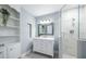 Nicely decorated bathroom with a glass-enclosed shower, a marble vanity and stylish shelving at 5625 Atlantic N Ave, St Petersburg, FL 33703