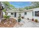 Well-maintained white home with a black front door, landscaped yard and driveway at 5625 Atlantic N Ave, St Petersburg, FL 33703