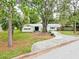Charming single-story home with a well-manicured lawn, mature trees, and a winding driveway at 5625 Atlantic N Ave, St Petersburg, FL 33703