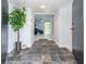 Inviting foyer with slate tile flooring, decorative plant, and view into the living area at 5625 Atlantic N Ave, St Petersburg, FL 33703