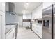 Well-equipped white kitchen with stainless steel appliances, granite countertops, and light wood flooring at 5625 Atlantic N Ave, St Petersburg, FL 33703