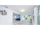 Bright, open living room with light wood floors, large windows, and a glimpse of a stylish blue sofa at 5625 Atlantic N Ave, St Petersburg, FL 33703