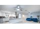 Modern living room featuring stylish blue sofa, light wood floors and view into the kitchen at 5625 Atlantic N Ave, St Petersburg, FL 33703