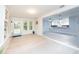 Open living space with light wood floors seamlessly connecting the sunroom and kitchen at 5625 Atlantic N Ave, St Petersburg, FL 33703